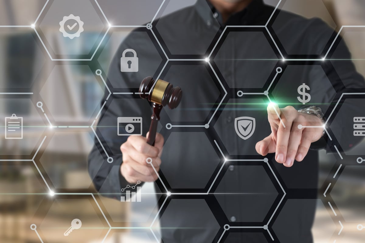 A person in a black shirt holds a gavel while interacting with digital security icons. This moment reflects the merging of law and technology in modern legal frameworks.